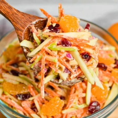 A vibrant Carrot Apple Salad featuring grated carrots and sliced apples.