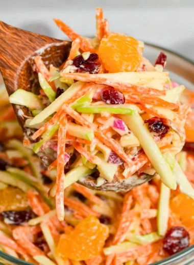 A vibrant Carrot Apple Salad featuring grated carrots and sliced apples.