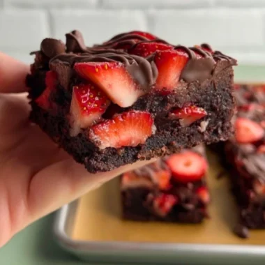 Delicious chocolate covered strawberry brownies topped with fresh strawberries.