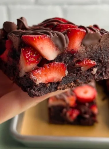 Delicious chocolate covered strawberry brownies topped with fresh strawberries.