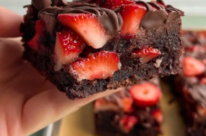 Delicious chocolate covered strawberry brownies topped with fresh strawberries.
