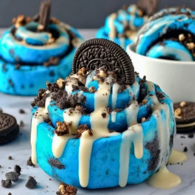 Cookie Monster cinnamon rolls with blue swirl icing on a plate