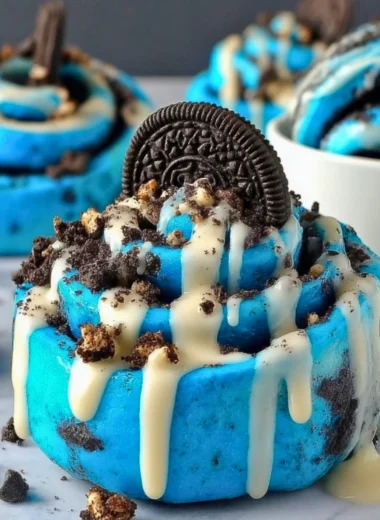 Cookie Monster cinnamon rolls with blue swirl icing on a plate