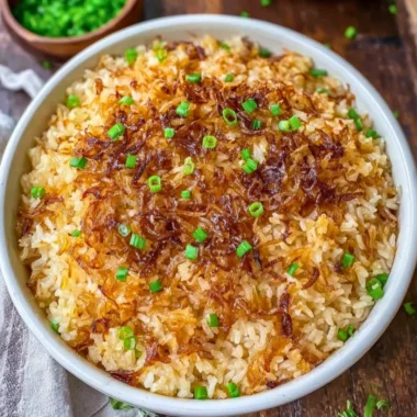 Bowl of French Onion Butter Rice garnished with herbs and onions.