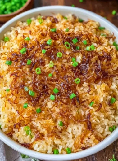Bowl of French Onion Butter Rice garnished with herbs and onions.