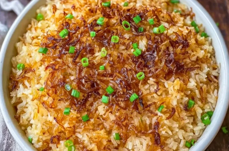 Bowl of French Onion Butter Rice garnished with herbs and onions.
