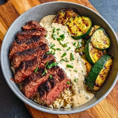Grilled steak bowl with sauce and grilled zucchini on a plate