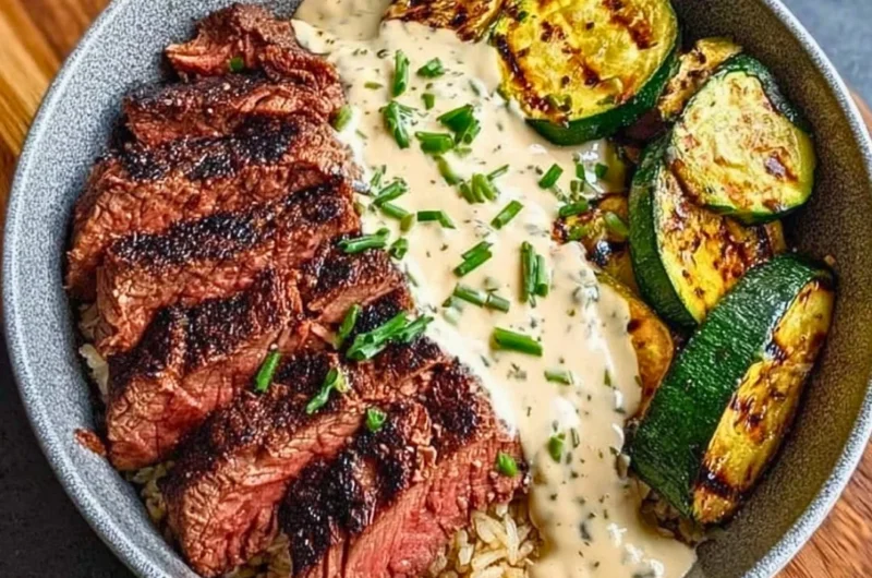 Grilled steak bowl with sauce and grilled zucchini on a plate