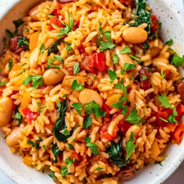 Dish of Mediterranean Rice and Beans garnished with herbs and vegetables.