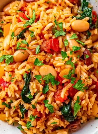 Dish of Mediterranean Rice and Beans garnished with herbs and vegetables.
