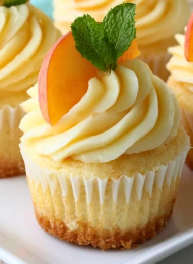 Peach and honey cheesecake cupcakes topped with fresh fruit and honey drizzle
