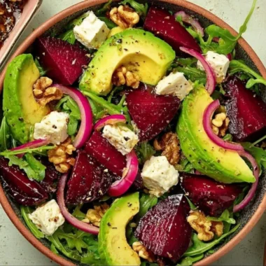 Roasted beet arugula salad topped with feta cheese and walnuts