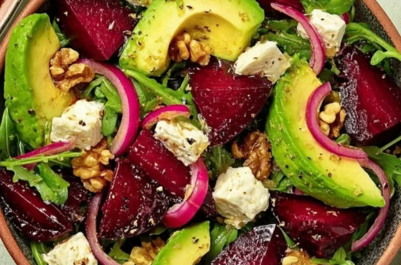 Roasted beet arugula salad topped with feta cheese and walnuts