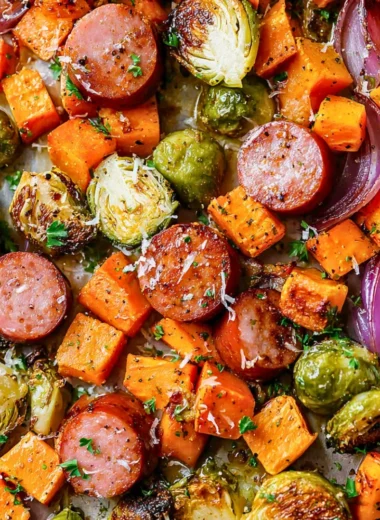 Sheet pan filled with sausage and colorful fall vegetables ready to bake