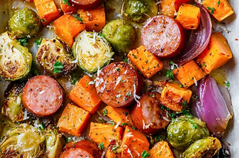 Sheet pan filled with sausage and colorful fall vegetables ready to bake