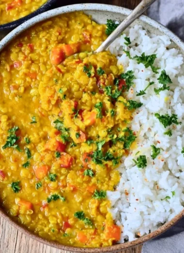 Bowl of vegan red lentil dahl with spices and herbs