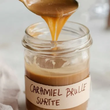Caramel Brulee Latte Syrup in a glass with coffee and caramel drizzle