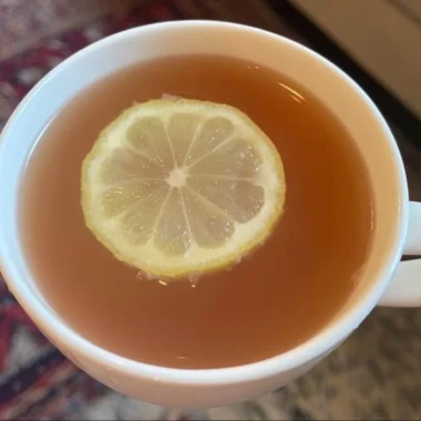 A refreshing glass of Citrus Mint Peach Tea with fresh fruit and mint leaves.