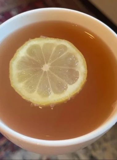 A refreshing glass of Citrus Mint Peach Tea with fresh fruit and mint leaves.