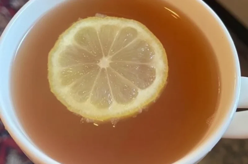 A refreshing glass of Citrus Mint Peach Tea with fresh fruit and mint leaves.