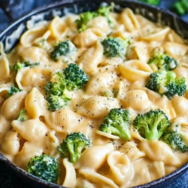 Creamy broccoli mac and cheese in a bowl with fresh broccoli florets
