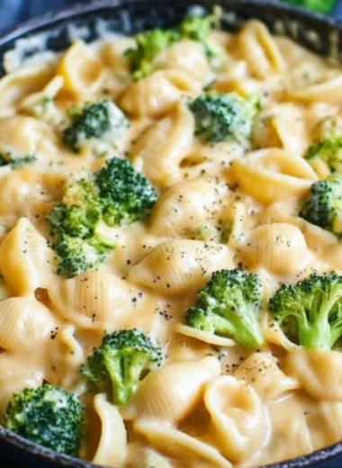 Creamy broccoli mac and cheese in a bowl with fresh broccoli florets
