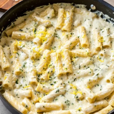 Bowl of lemon garlic cream sauce on a table with fresh ingredients