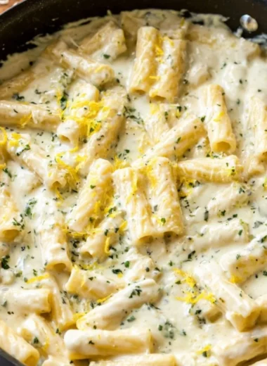 Bowl of lemon garlic cream sauce on a table with fresh ingredients