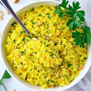 Bowl of Mediterranean yellow rice garnished with herbs and spices