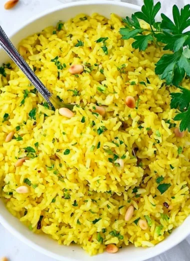 Bowl of Mediterranean yellow rice garnished with herbs and spices