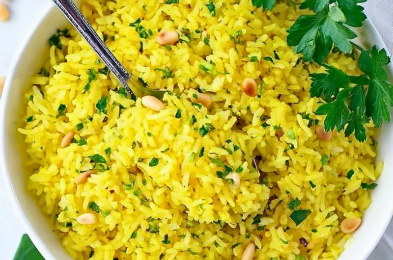 Bowl of Mediterranean yellow rice garnished with herbs and spices