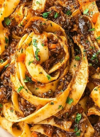 Delicious Mushroom Ragu served over pasta, garnished with fresh herbs.