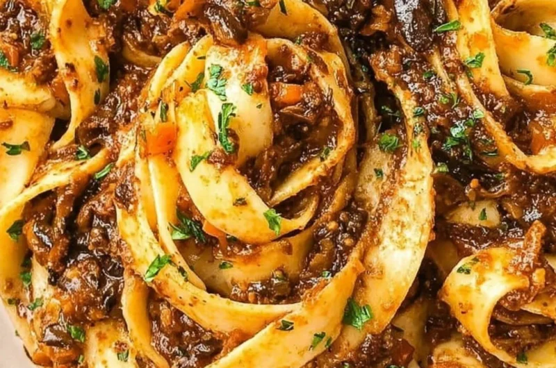 Delicious Mushroom Ragu served over pasta, garnished with fresh herbs.