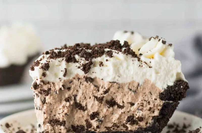 Delicious Oreo Pudding Pie topped with whipped cream and Oreo crumbles