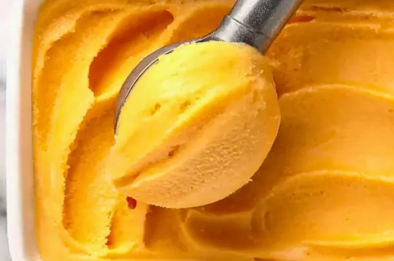 Delicious peach sorbet served in a chilled bowl with fresh peach slices