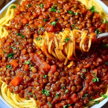 A bowl of hearty Vegan Bolognese pasta topped with fresh herbs.