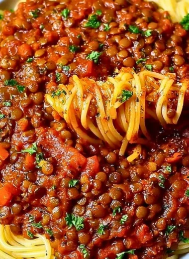 A bowl of hearty Vegan Bolognese pasta topped with fresh herbs.