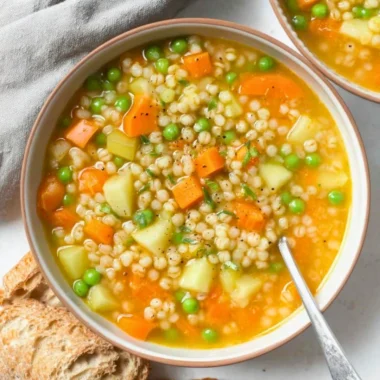 Bowl of hearty homemade barley soup with vegetables and herbs