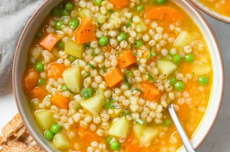 Bowl of hearty homemade barley soup with vegetables and herbs