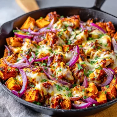 BBQ chicken sweet potato skillet served in a cast iron pan with colorful vegetables