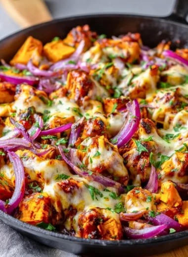 BBQ chicken sweet potato skillet served in a cast iron pan with colorful vegetables