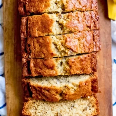 Delicious homemade banana bread sliced on a wooden cutting board