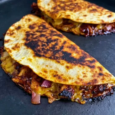 Delicious Blackstone Hot Honey BBQ Chicken Quesadillas with melted cheese and toppings