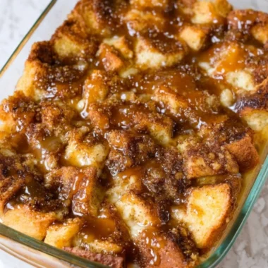Delicious homemade bread pudding with spices and raisins in a white baking dish