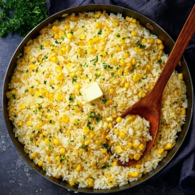 Plate of buttered corn rice with fresh herbs and butter topping