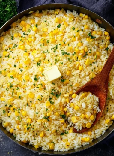 Plate of buttered corn rice with fresh herbs and butter topping
