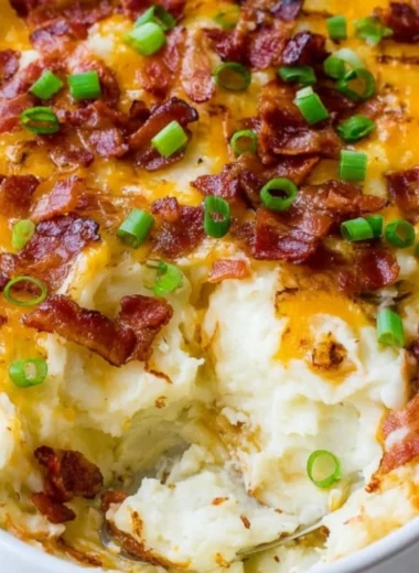 Delicious Loaded Mashed Potato Casserole topped with cheese and green onions