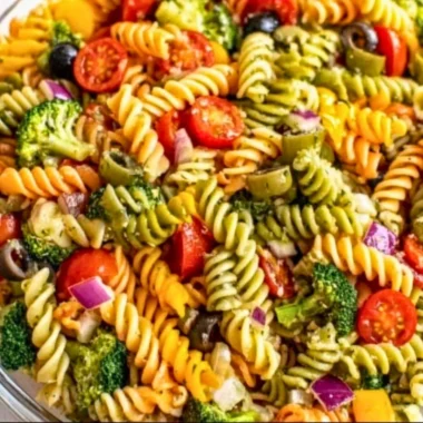 Colorful pasta salad with vegetables and dressing in a bowl