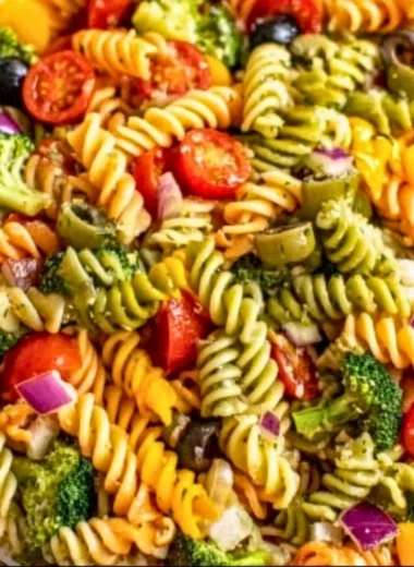 Colorful pasta salad with vegetables and dressing in a bowl