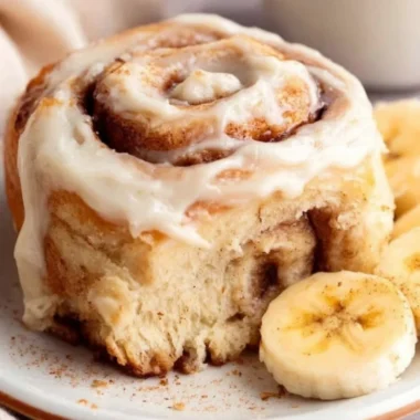 Freshly baked banana bread cinnamon rolls drizzled with icing